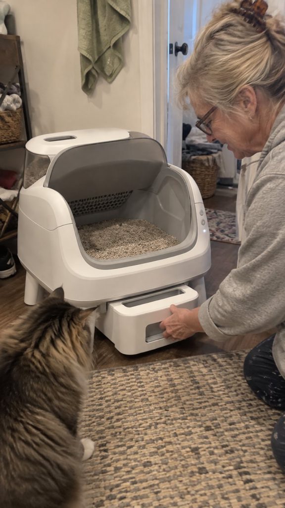A customer pulling out the sealed waste drawer under the self-cleaning litter box